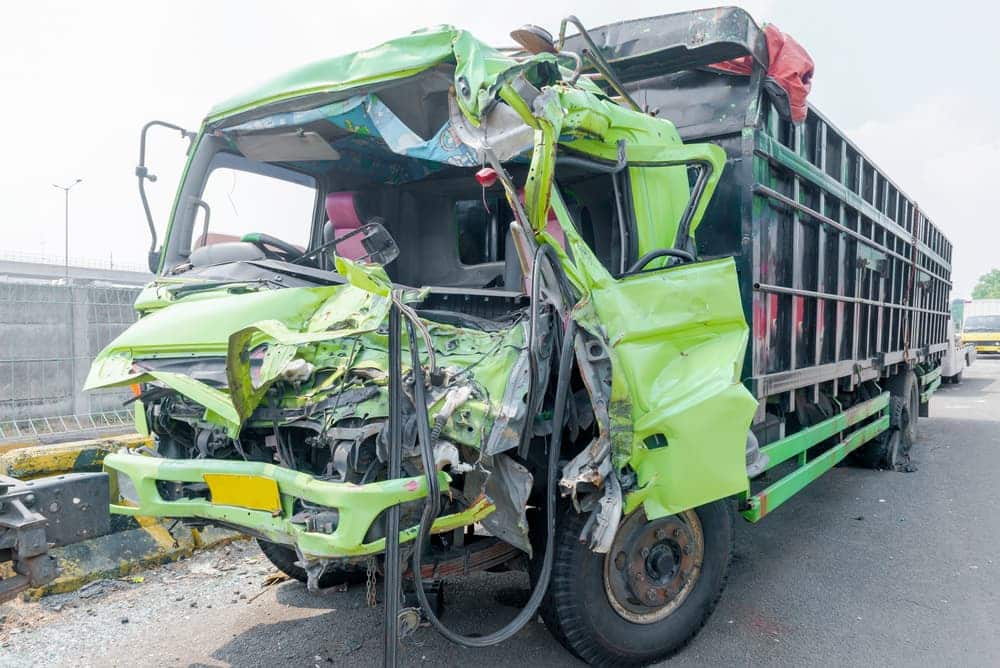 The truck is damaged due to a collision on the road.

