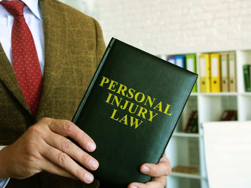 Personal injury law: A lawyer in a suit holds a book.