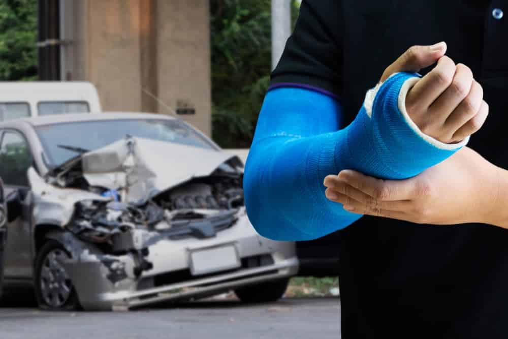 Close up man holding hand with blue bandage as arm injury concept with car accident.
