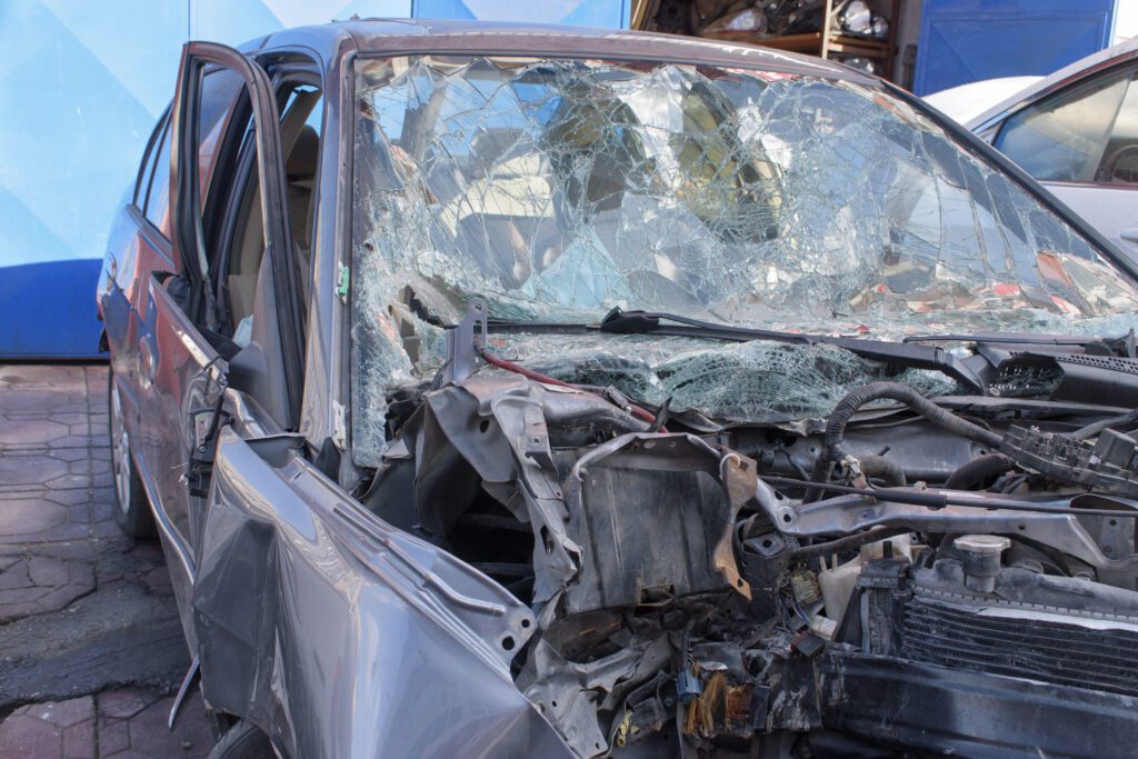 Severely damaged car with a shattered windshield and crumpled front end after a serious accident.