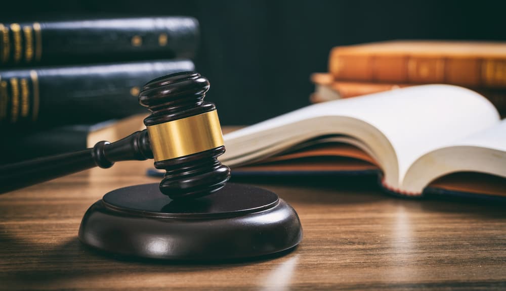 Law studies. Judge gavel on a wooden desk, blur legal books background.