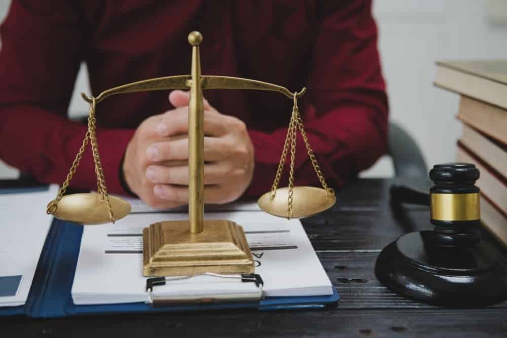 male lawyer meticulously reviews legal documents, ensuring accuracy and compliance for an upcoming court case. 
