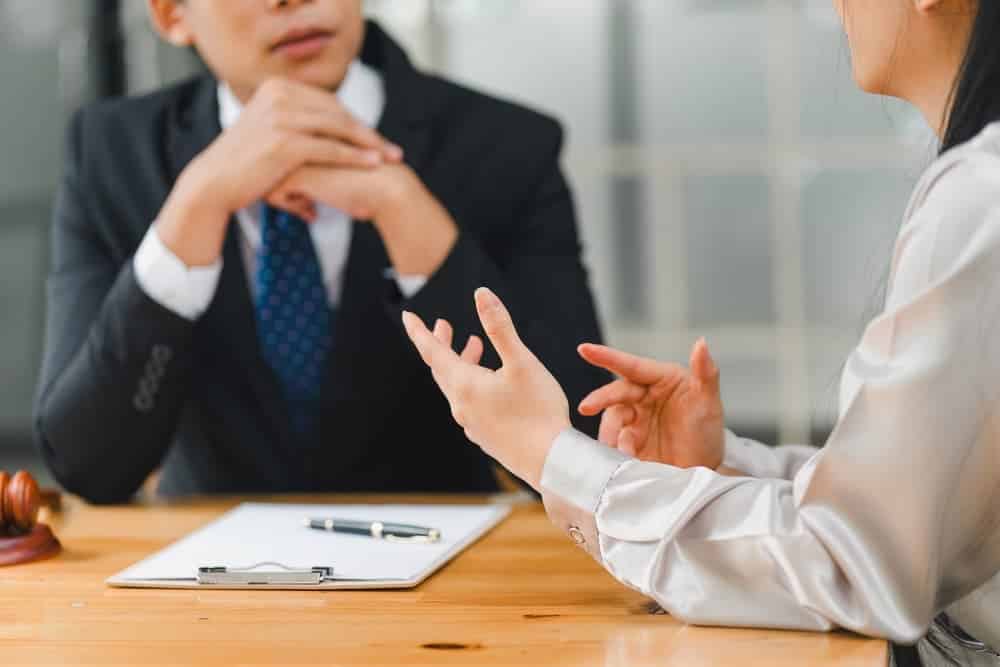 A lawyer reviews the statute of limitations while consulting with male lawyer and clients.