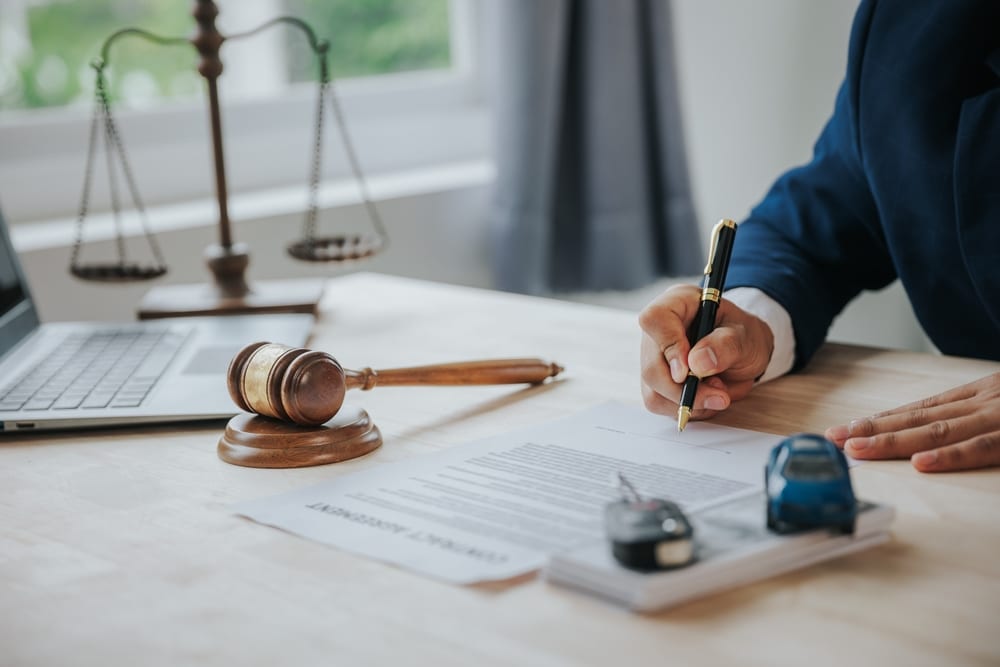 Abogados de accidentes automovilísticos de Oceanside revisan un reclamo por accidente de vehículo con documentos legales y un mazo.
