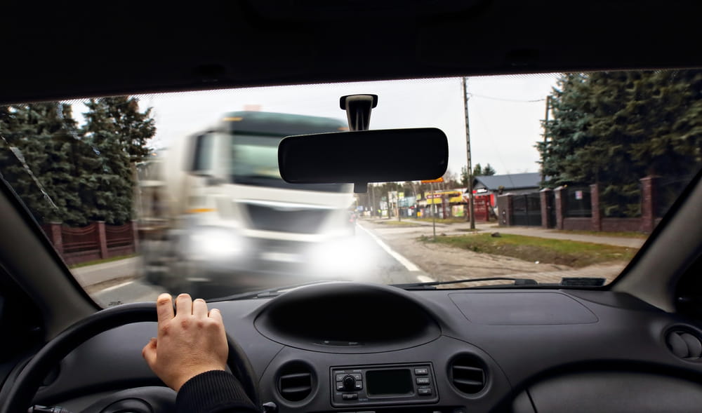 Conductor aproximándose a un camión comercial de gran tamaño antes de una posible colisión en la autopista