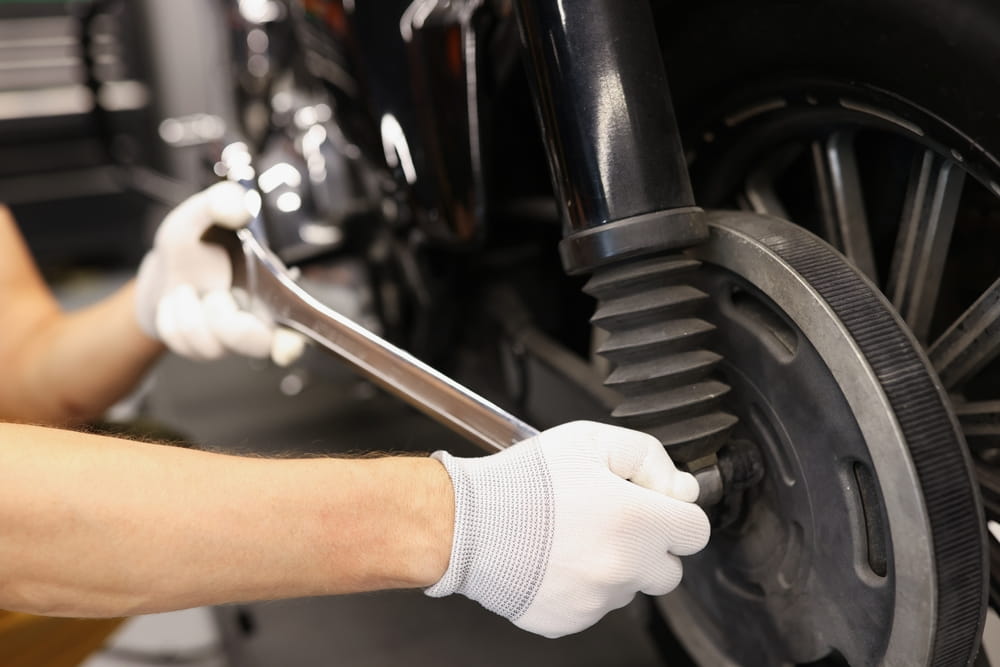 Mecánico reparando el sistema de frenos de la scooter durante una inspección de mantenimiento.
