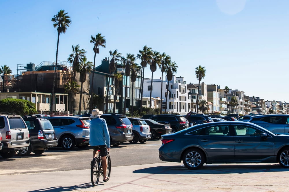 Tourist traffic and cyclist near beachfront parking along Coast Highway in Oceanside