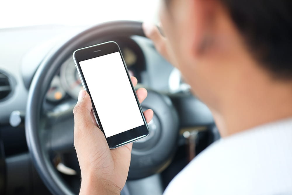 Rideshare driver looking at a phone while driving