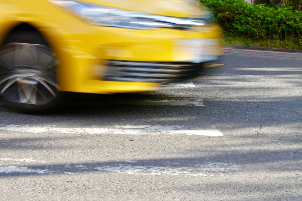 Blurred yellow vehicle speeding through an intersection in San Diego