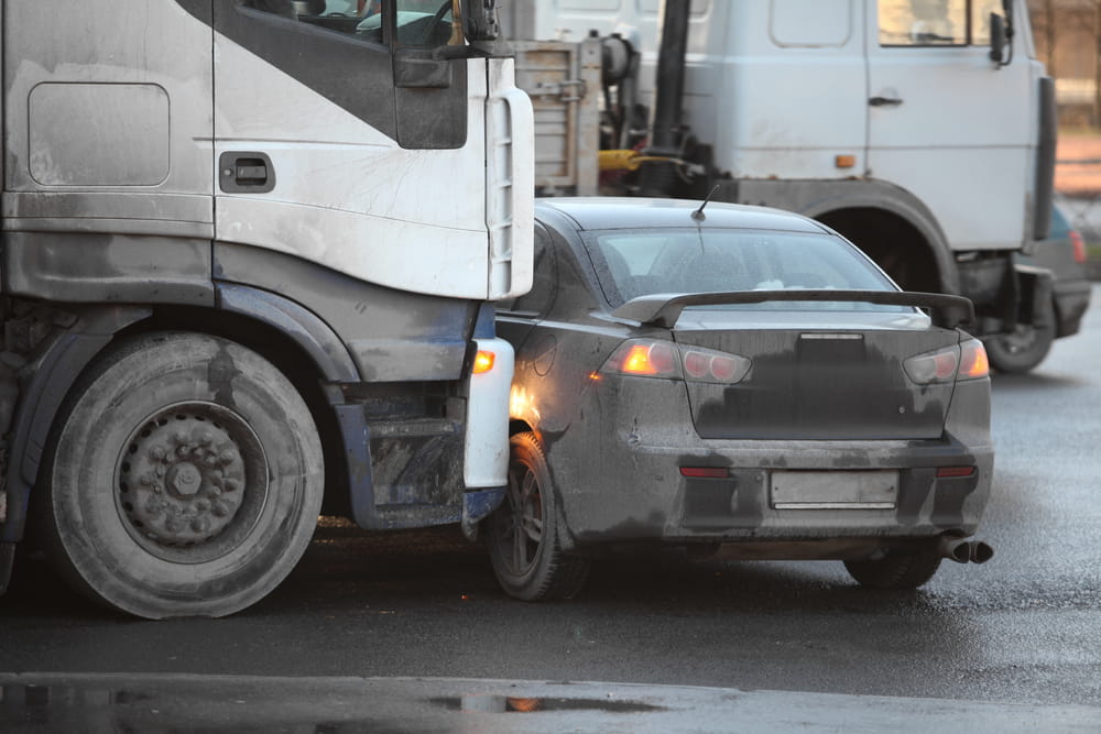 Passenger vehicle involved in a collision with a semi-truck on a busy roadway