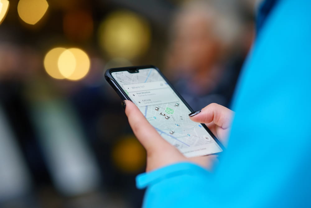 Passenger reviewing Uber or Lyft trip details on a smartphone after a rideshare accident